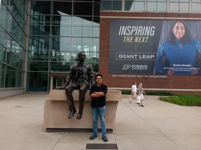 A photo beside a seated statue outside a Purdue building.